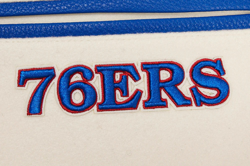 Embroidered '76ERS' text on a sports team jersey with blue and red colors.